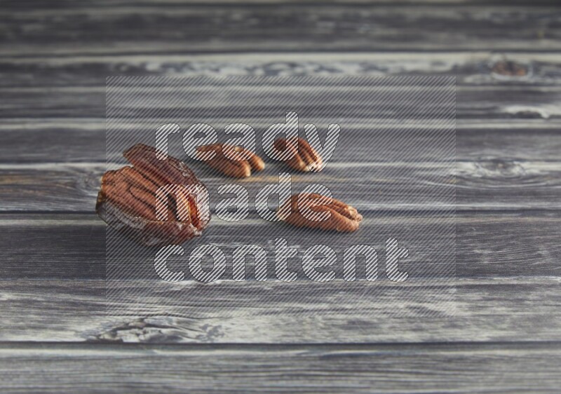 pecan stuffed madjoul date on a wooden grey background