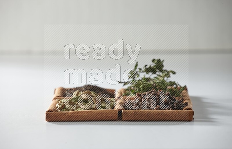 4 squares of cinnamon sticks full of tea, cardamom, mint and cloves on white flooring