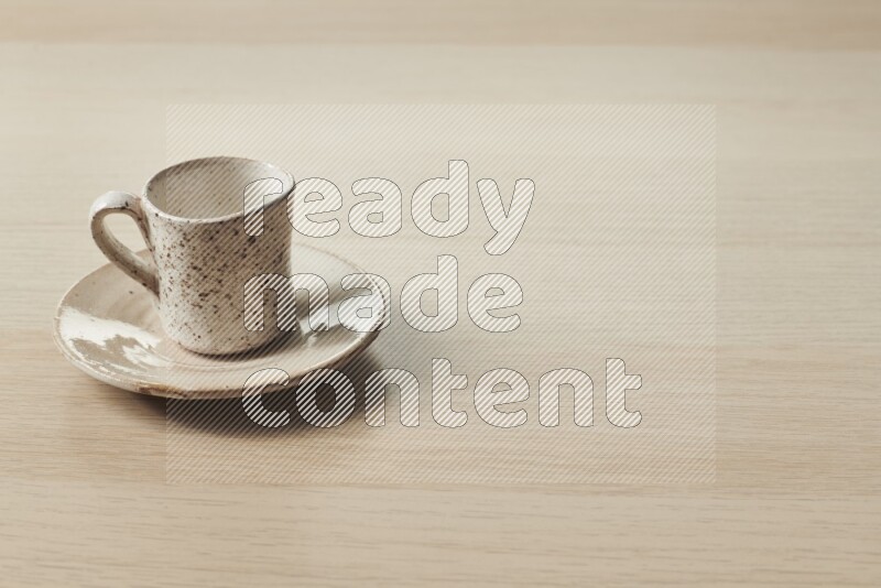 A pottery cup on light wooden background