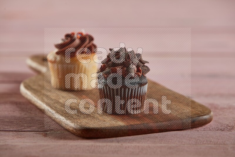 Chocolate mini cupcake topped with chocolate curls on a wooden board