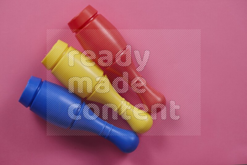 Multicolored plastic bowling pins on different colored backgrounds background (kids toys)