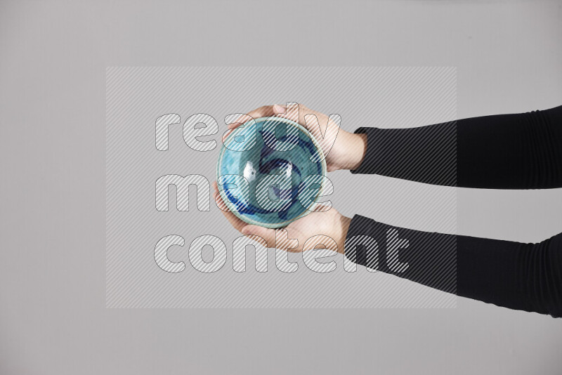 A woman in black abaya holding different pottery essentials in different positions