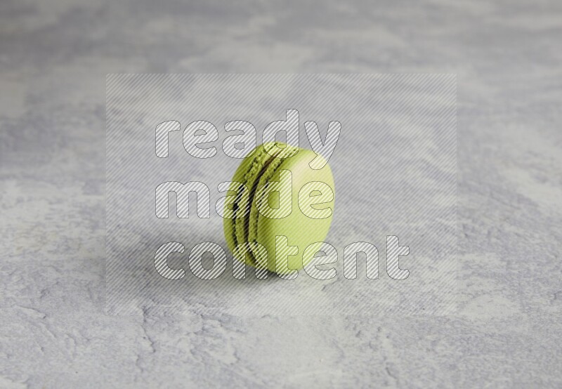 45º Shot of Yellow Lime macaron on white  marble background