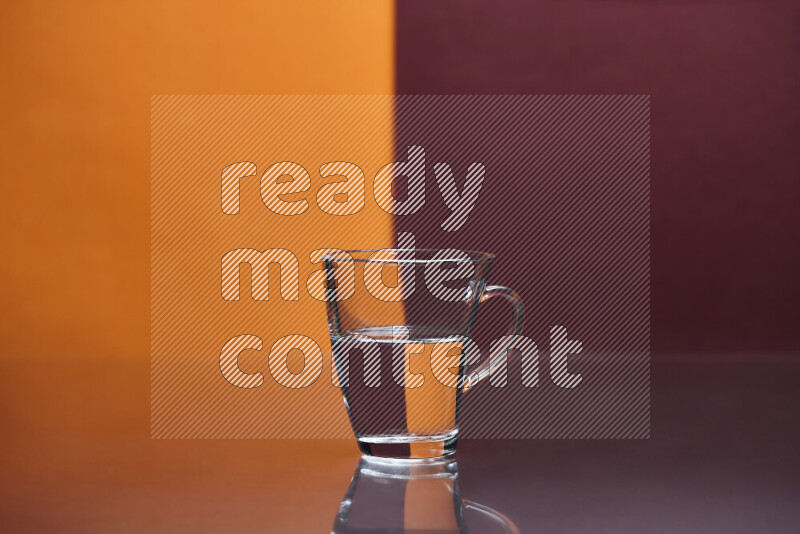 The image features a clear glassware filled with water, set against orange and dark red background