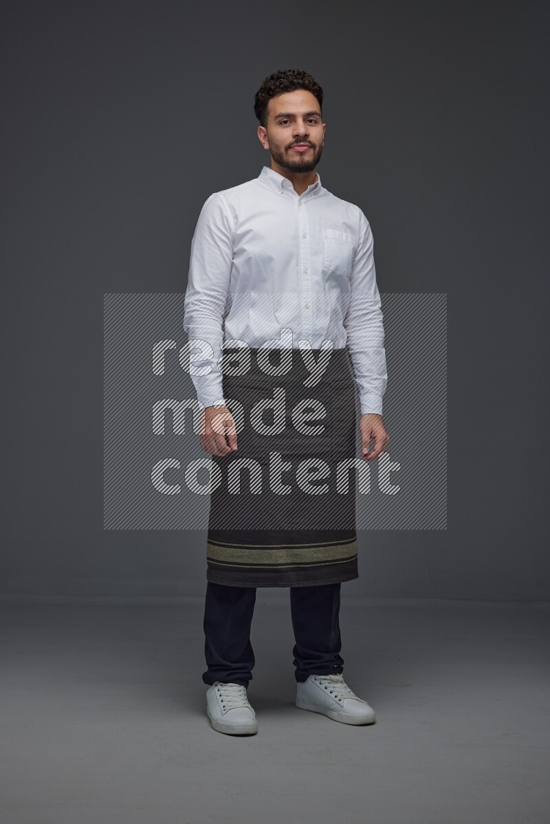 A man wearing smart casual and apron standing and making multi poses eye level on a gray background
