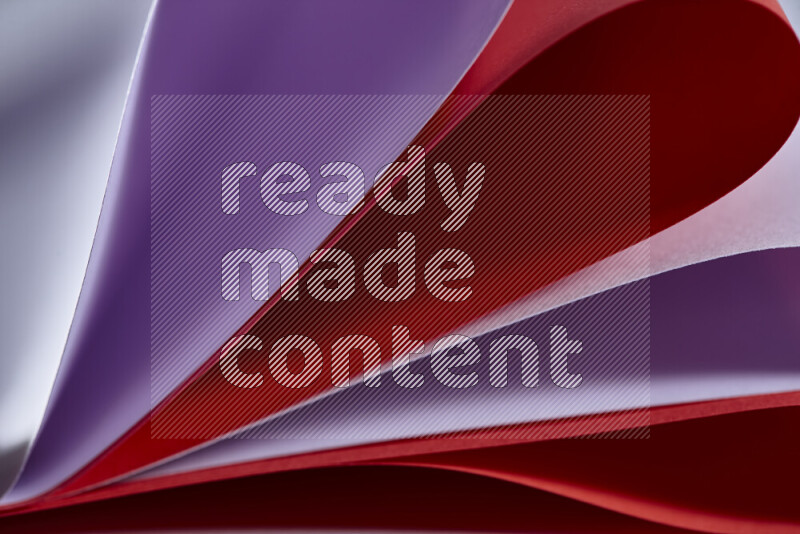 An abstract art showing purple and red paper sheets arranged in an overlapping curves