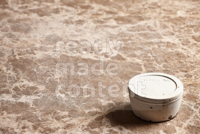 A white pottery bowl on beige marble background