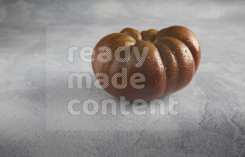 45 degree single heirloom tomato on a light blue textured background