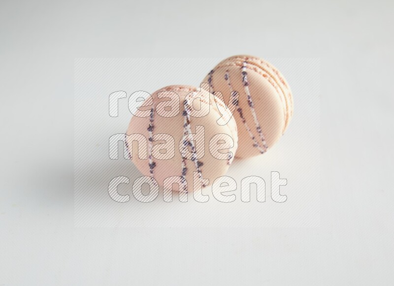 45º Shot of two pink orange blossom macarons on white background
