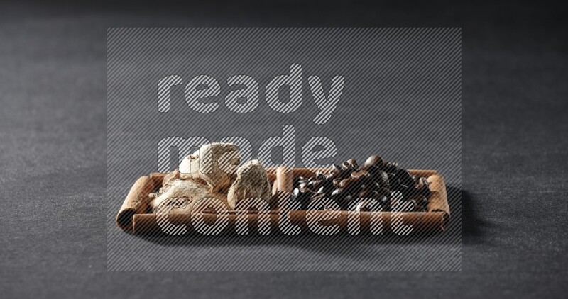 2 squares of cinnamon sticks full of coffee beans and ginger on black flooring