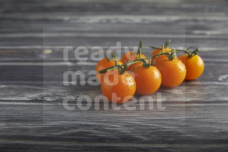 orange cherry tomato vein on a textured grey wooden background 45 degree