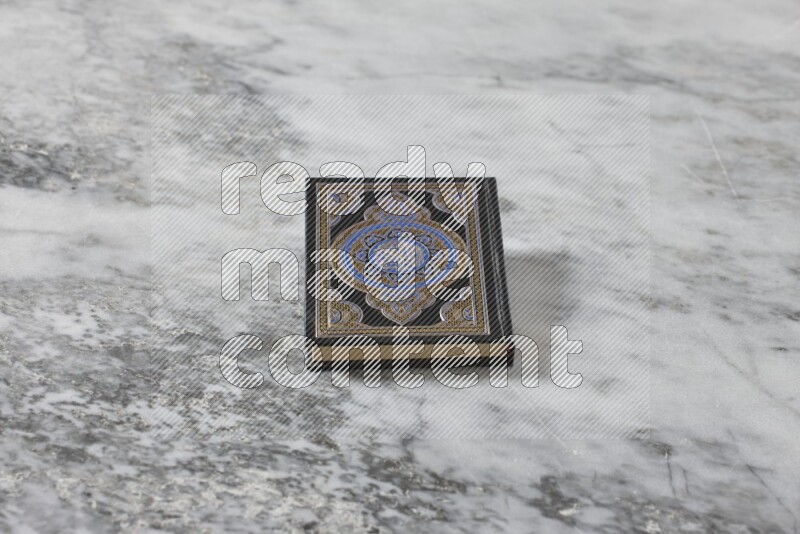 Quran with a prayer beads on grey marble background