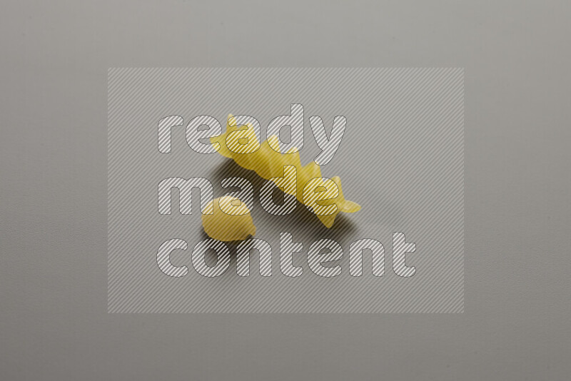 Shells pasta with other types of pasta on grey background